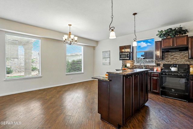 11353 W Ranch Ct, El Paso, TX 79934 - kitchen with black gas stove, stainless steel microwave, under cabinet range hood, tasteful backsplash, and dark wood-type flooring