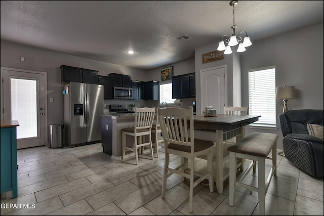 5949 Hidden Palms Dr, El Paso, TX 79924 - dining space with a chandelier, a textured ceiling, and light tile patterned flooring