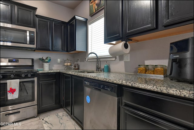5949 Hidden Palms Dr, El Paso, TX 79924 - kitchen with stainless steel appliances, dark cabinetry, and light stone counters