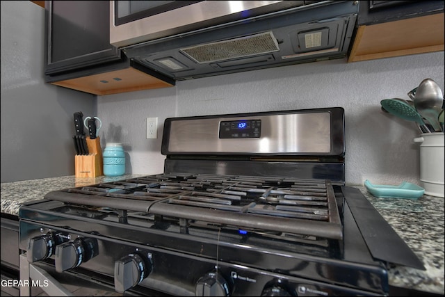 5949 Hidden Palms Dr, El Paso, TX 79924 - kitchen view of gas range oven, a textured wall, and stone countertops