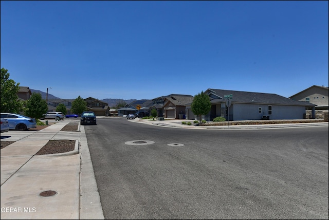5949 Hidden Palms Dr, El Paso, TX 79924 - view of asphalt street with sidewalks, a residential view, curbs, and traffic signs