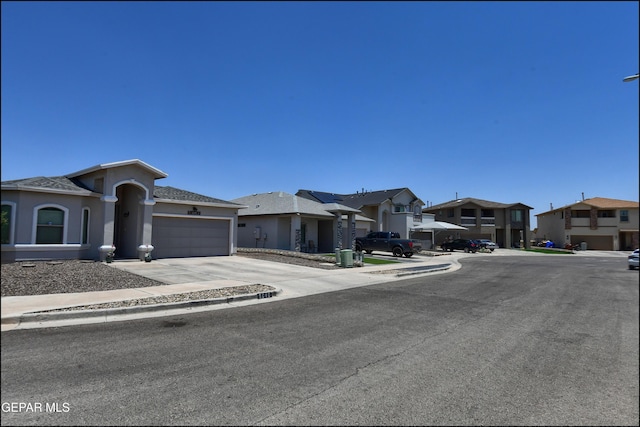5949 Hidden Palms Dr, El Paso, TX 79924 - view of front of property featuring a residential view, driveway, stucco siding, and an attached garage