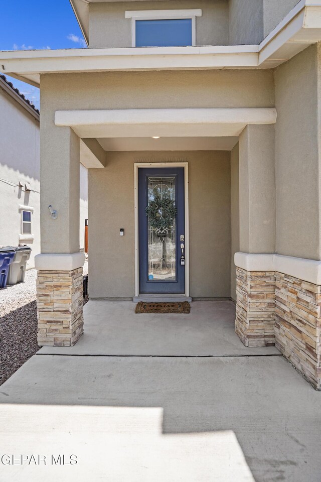 2228 Thawline Pl, El Paso, TX 79911 - view of exterior entry with stone siding, stucco siding, and covered porch