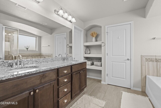 2228 Thawline Pl, El Paso, TX 79911 - full bath with double vanity, a bath, and wood finished floors