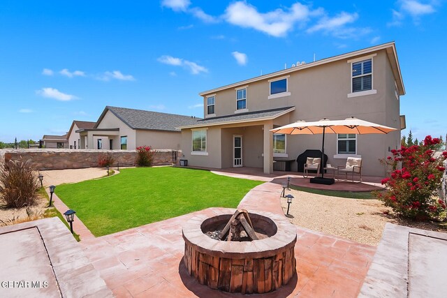2228 Thawline Pl, El Paso, TX 79911 - rear view of house with a fire pit, stucco siding, a patio, and a lawn
