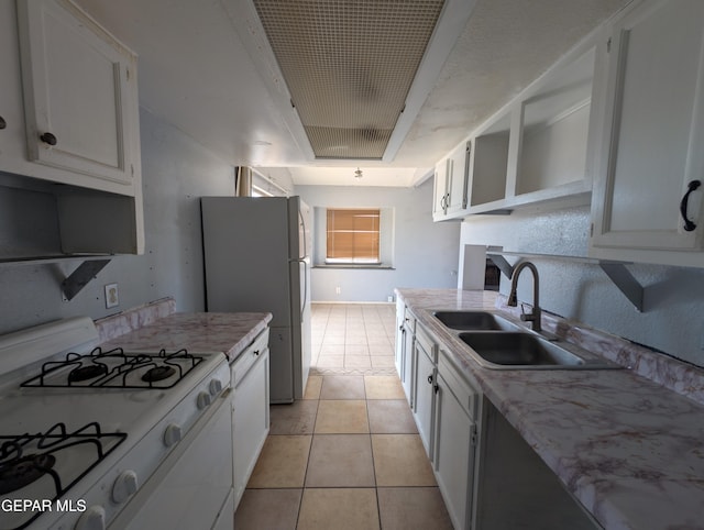 11828 Tracy Austin Ln, El Paso, TX 79936 - kitchen with white appliances, light tile patterned floors, and white cabinets