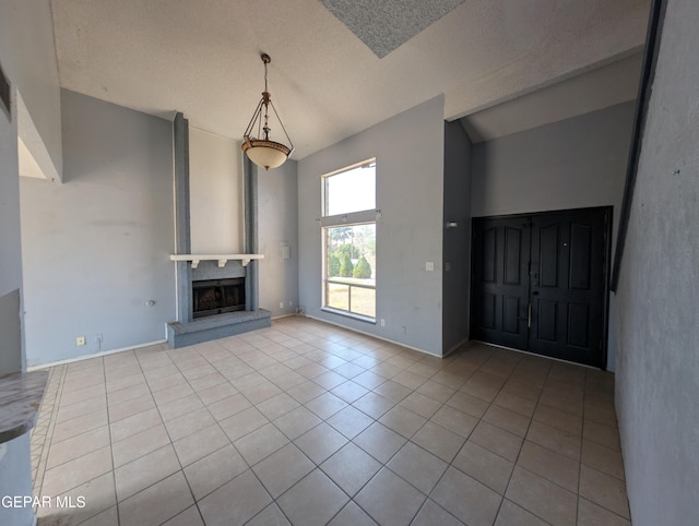 11828 Tracy Austin Ln, El Paso, TX 79936 - unfurnished living room with tile patterned flooring, vaulted ceiling, and a fireplace with raised hearth