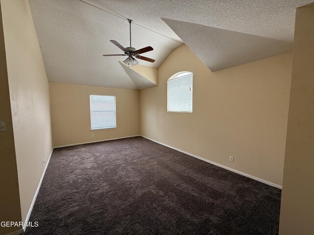 11025 Acoma St, El Paso, TX 79934 - spare room featuring ceiling fan, dark carpet, a textured ceiling, and vaulted ceiling