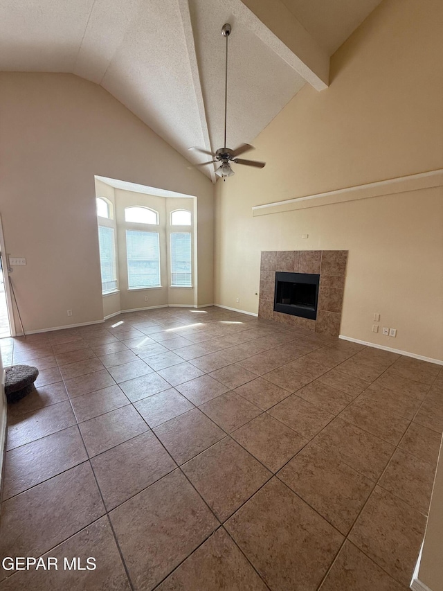 11025 Acoma St, El Paso, TX 79934 - unfurnished living room with a ceiling fan, tile patterned flooring, a tile fireplace, a textured ceiling, and high vaulted ceiling