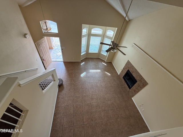 11025 Acoma St, El Paso, TX 79934 - unfurnished living room featuring high vaulted ceiling, ceiling fan, and a tile fireplace
