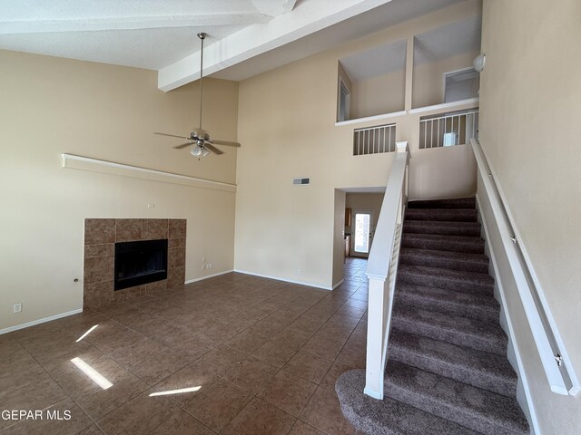 11025 Acoma St, El Paso, TX 79934 - unfurnished living room featuring tile patterned flooring, a ceiling fan, stairway, beamed ceiling, and a fireplace
