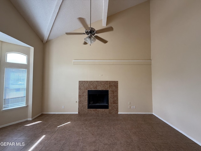 11025 Acoma St, El Paso, TX 79934 - unfurnished living room featuring ceiling fan, tile patterned flooring, vaulted ceiling, a tiled fireplace, and a textured ceiling