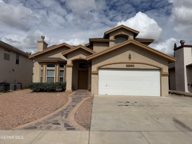 11025 Acoma St, El Paso, TX 79934 - mediterranean / spanish home featuring stucco siding, concrete driveway, a chimney, and a garage
