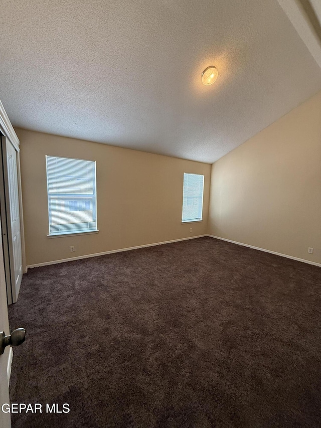 11025 Acoma St, El Paso, TX 79934 - unfurnished room featuring plenty of natural light, a textured ceiling, and dark colored carpet