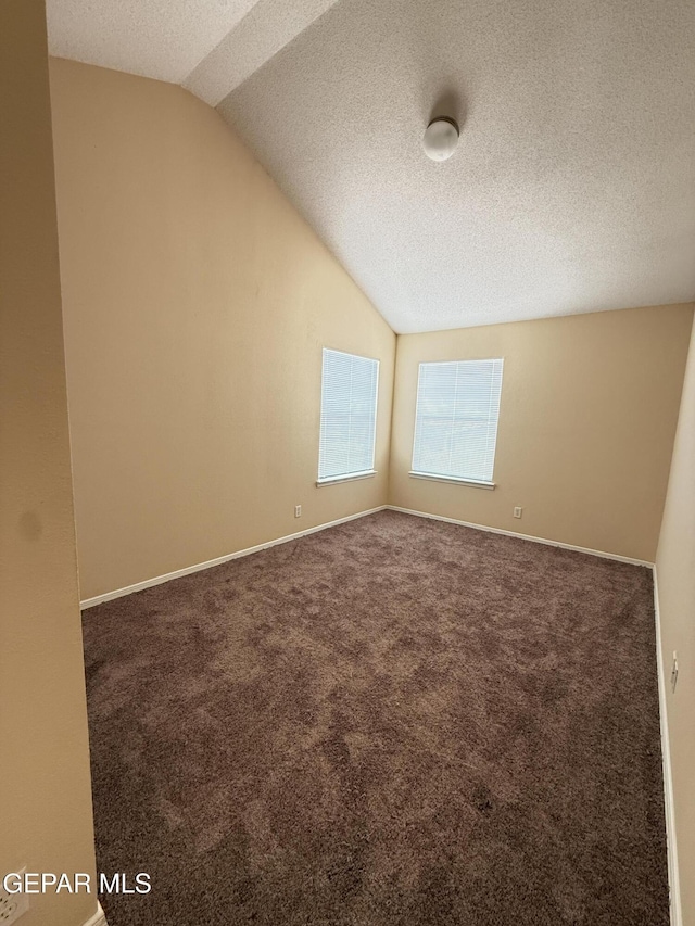 11025 Acoma St, El Paso, TX 79934 - spare room with vaulted ceiling, a textured ceiling, and carpet floors
