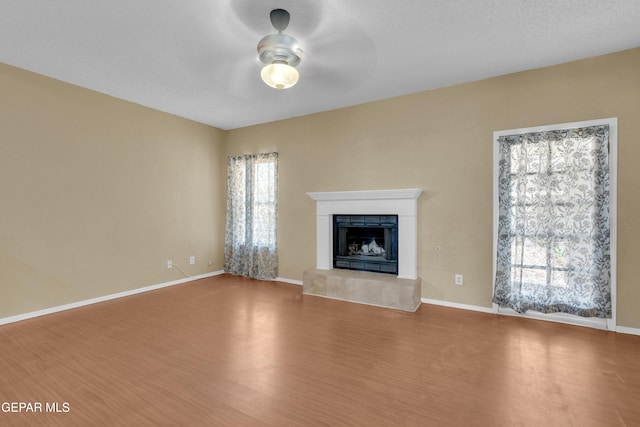 4328 Loma Alegre Dr, El Paso, TX 79934 - unfurnished living room with a ceiling fan, plenty of natural light, a fireplace, and wood finished floors