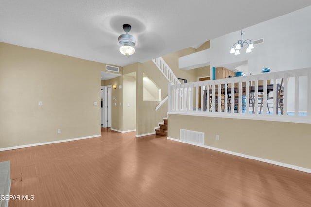 4328 Loma Alegre Dr, El Paso, TX 79934 - unfurnished living room featuring a ceiling fan, a chandelier, wood finished floors, and stairway