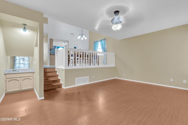 4328 Loma Alegre Dr, El Paso, TX 79934 - unfurnished living room with light wood-style flooring, stairs, a chandelier, and a ceiling fan