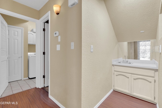 4328 Loma Alegre Dr, El Paso, TX 79934 - bathroom with washer / dryer, wood finished floors, a textured wall, vanity, and a textured ceiling