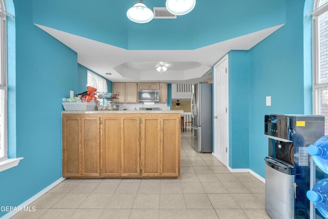 4328 Loma Alegre Dr, El Paso, TX 79934 - kitchen with stainless steel appliances, a tray ceiling, light countertops, ceiling fan, and light tile patterned flooring