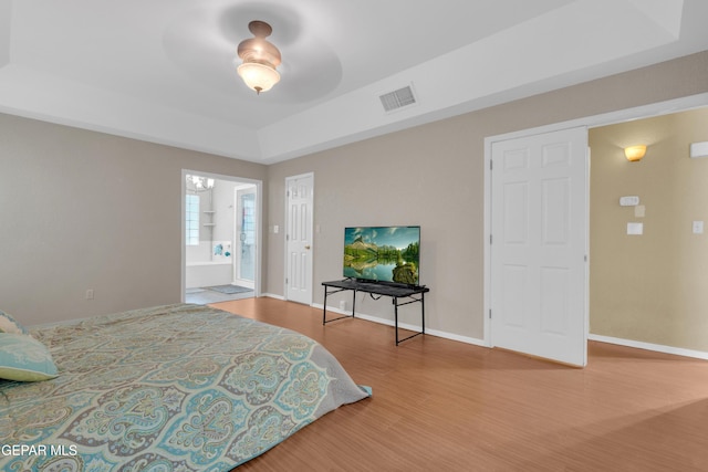4328 Loma Alegre Dr, El Paso, TX 79934 - bedroom with wood finished floors, a raised ceiling, connected bathroom, and a chandelier