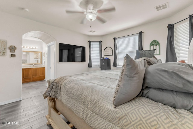 237 Gonzalo Cir, El Paso, TX 79932 - bedroom featuring light wood-style flooring, arched walkways, ensuite bathroom, and a ceiling fan