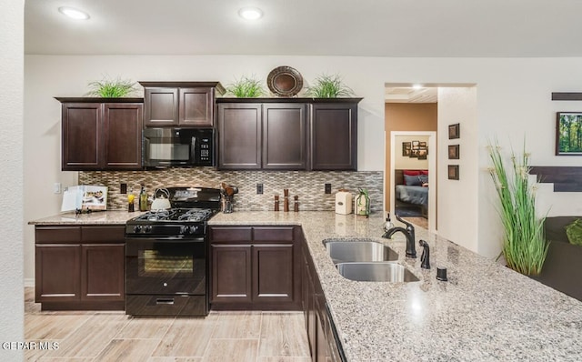 15249 Apex Ct, El Paso, TX 79938 - kitchen featuring black appliances, decorative backsplash, light stone countertops, dark brown cabinetry, and light wood-type flooring