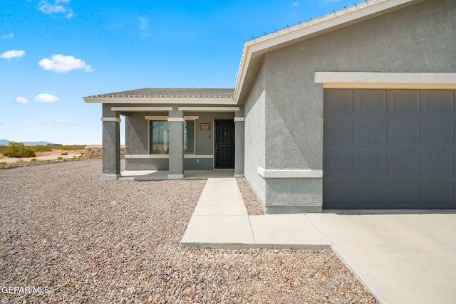 14207 Desierto Bonito St, Horizon City, TX 79928 - property entrance featuring an attached garage and stucco siding
