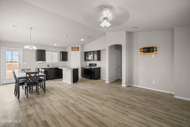 14207 Desierto Bonito St, Horizon City, TX 79928 - kitchen with gas range oven, ceiling fan, arched walkways, a chandelier, and a kitchen island