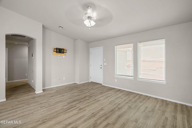 14207 Desierto Bonito St, Horizon City, TX 79928 - empty room featuring arched walkways, ceiling fan, light wood finished floors, and lofted ceiling