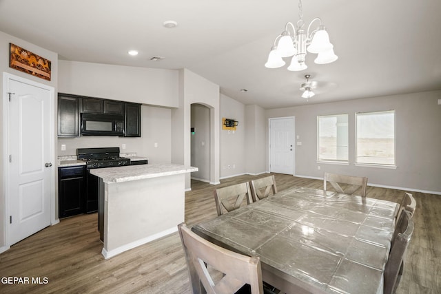 14207 Desierto Bonito St, Horizon City, TX 79928 - dining room with vaulted ceiling, a chandelier, arched walkways, and light wood-type flooring