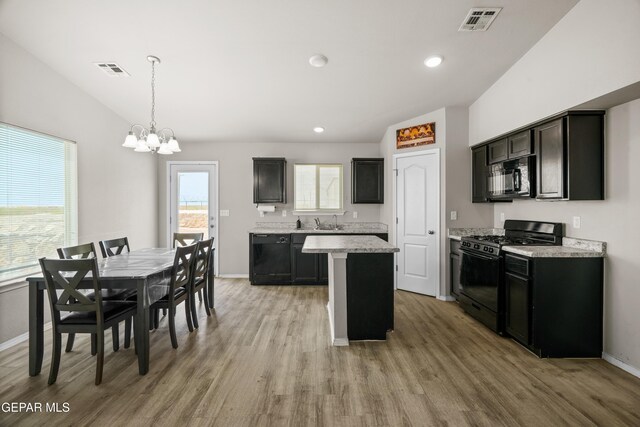14207 Desierto Bonito St, Horizon City, TX 79928 - kitchen with black appliances, a chandelier, light wood-type flooring, a kitchen island, and hanging light fixtures