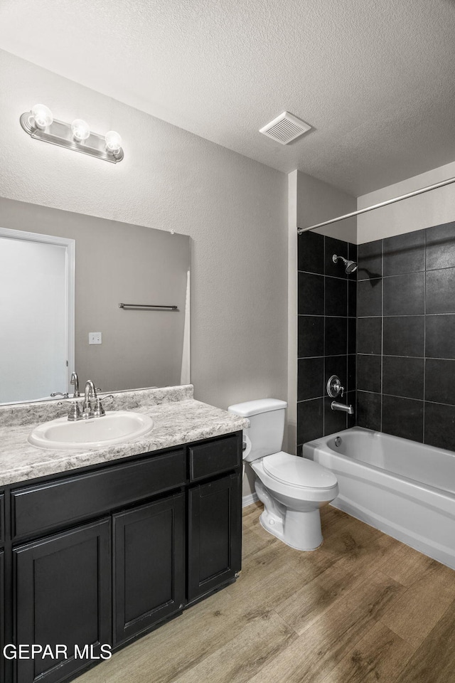 14207 Desierto Bonito St, Horizon City, TX 79928 - bathroom featuring wood finished floors, vanity, shower / washtub combination, and a textured ceiling