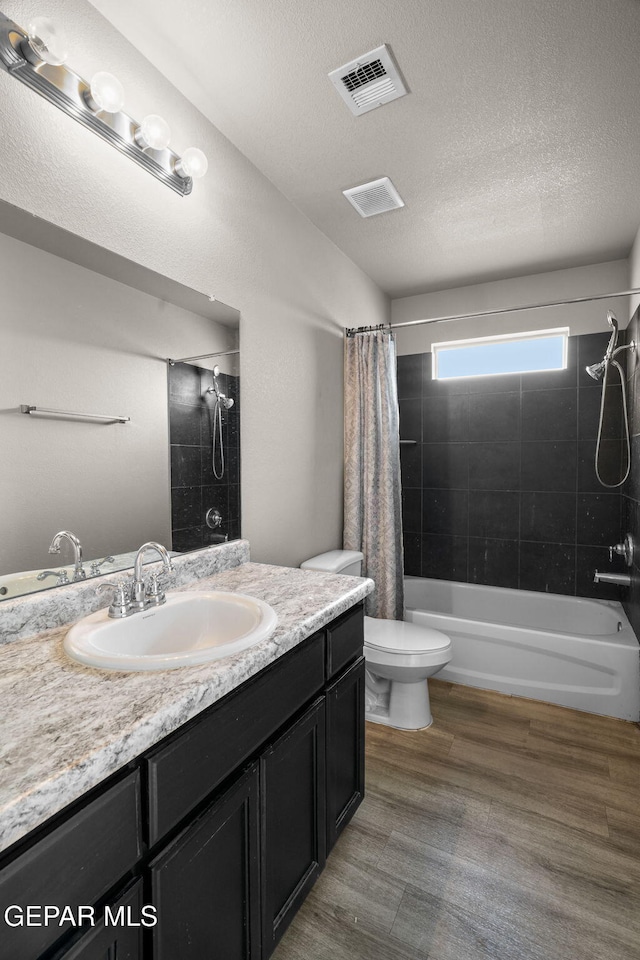 14207 Desierto Bonito St, Horizon City, TX 79928 - full bath with vanity, shower / bathtub combination with curtain, wood finished floors, and a textured ceiling