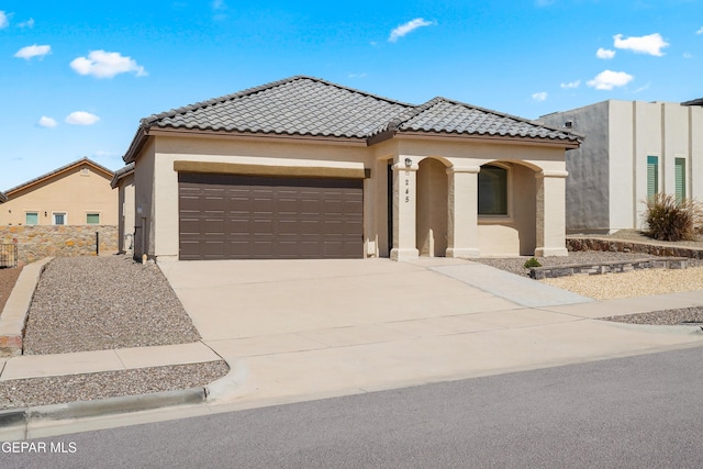 245 Hunstanton St, Horizon City, TX 79928 - mediterranean / spanish-style home featuring stucco siding, driveway, an attached garage, and a tile roof