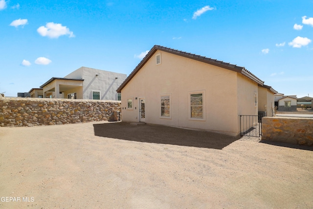 245 Hunstanton St, Horizon City, TX 79928 - back of house featuring a gate, stucco siding, and a tile roof