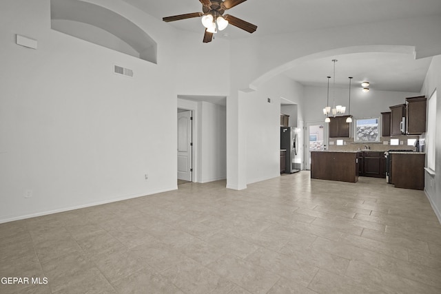 245 Hunstanton St, Horizon City, TX 79928 - unfurnished living room with a ceiling fan, arched walkways, a chandelier, and high vaulted ceiling