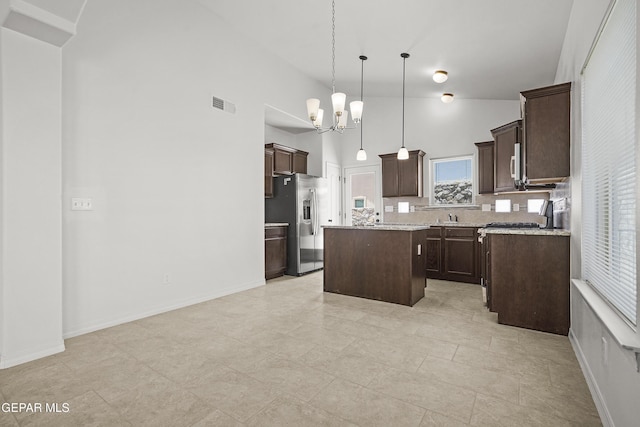 245 Hunstanton St, Horizon City, TX 79928 - kitchen featuring stainless steel fridge, high vaulted ceiling, a center island, dark brown cabinetry, and a chandelier