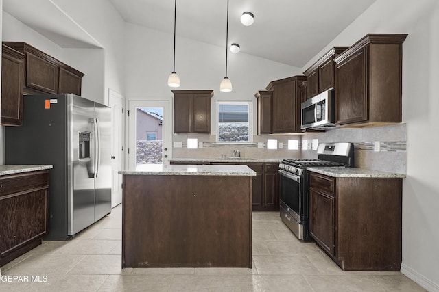 245 Hunstanton St, Horizon City, TX 79928 - kitchen with stainless steel appliances, dark brown cabinets, backsplash, a center island, and light stone countertops