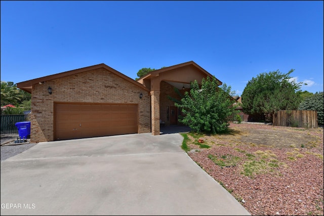 712 Rena Mae Ct, Las Cruces, NM 88005 - view of front of house featuring brick siding, concrete driveway, an attached garage, and stucco siding
