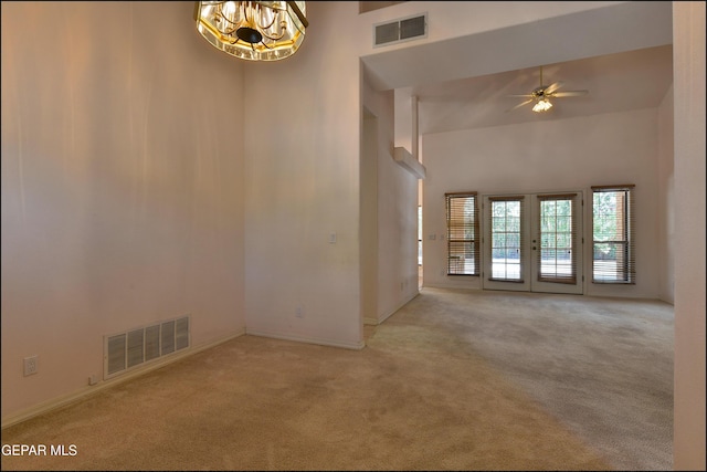 712 Rena Mae Ct, Las Cruces, NM 88005 - empty room with carpet flooring, a high ceiling, ceiling fan, a chandelier, and french doors