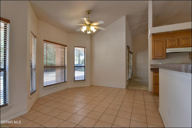 712 Rena Mae Ct, Las Cruces, NM 88005 - kitchen featuring under cabinet range hood, ceiling fan, vaulted ceiling, light tile patterned floors, and light brown cabinets