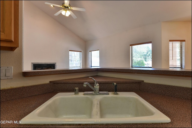 712 Rena Mae Ct, Las Cruces, NM 88005 - kitchen featuring dark countertops, a glass covered fireplace, ceiling fan, and high vaulted ceiling
