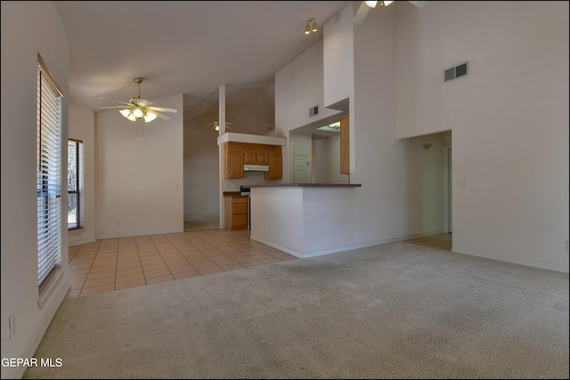 712 Rena Mae Ct, Las Cruces, NM 88005 - unfurnished living room with a ceiling fan, light carpet, high vaulted ceiling, and light tile patterned flooring