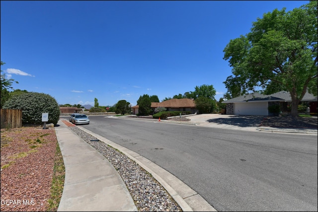 712 Rena Mae Ct, Las Cruces, NM 88005 - view of asphalt road featuring sidewalks, curbs, and traffic signs