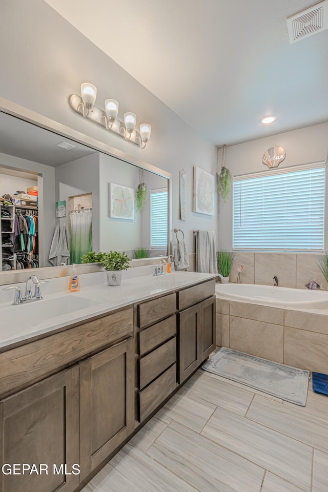 13010 Aberdare Dr, El Paso, TX 79928 - bathroom featuring double vanity, a bath, and a walk in closet