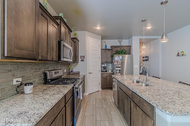 13010 Aberdare Dr, El Paso, TX 79928 - kitchen with appliances with stainless steel finishes, backsplash, a kitchen island with sink, dark brown cabinets, and recessed lighting