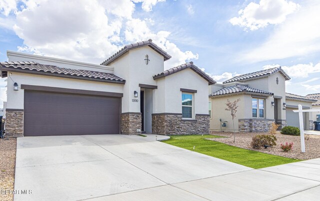 13010 Aberdare Dr, El Paso, TX 79928 - mediterranean / spanish house with stone siding, an attached garage, driveway, and stucco siding