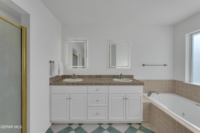 1121 Regal Ridge Dr, El Paso, TX 79912 - full bathroom featuring a jetted tub, double vanity, and a shower with door