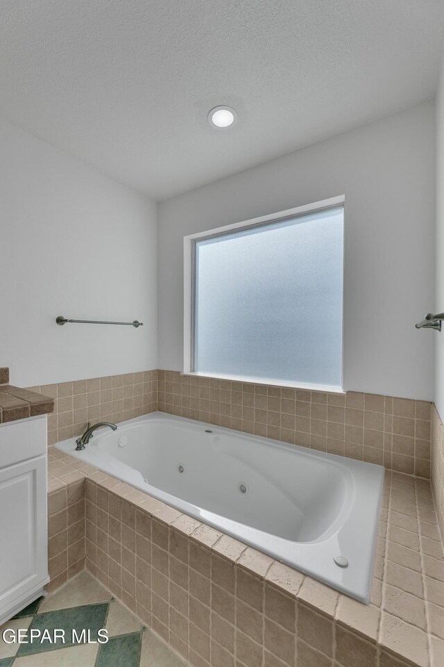 1121 Regal Ridge Dr, El Paso, TX 79912 - full bathroom with a tub with jets, vanity, tile patterned floors, a textured ceiling, and recessed lighting